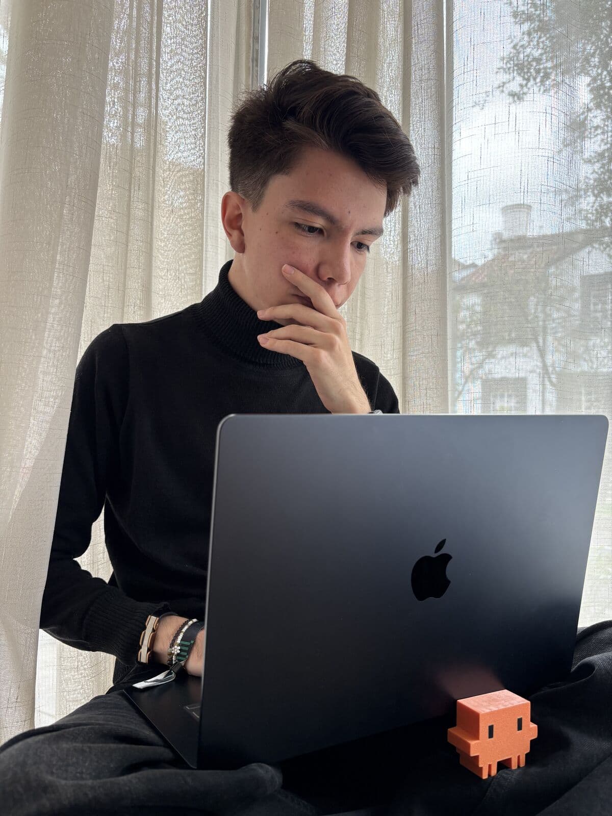 Lucas Leguizamo working on his laptop by a window in Bogotá